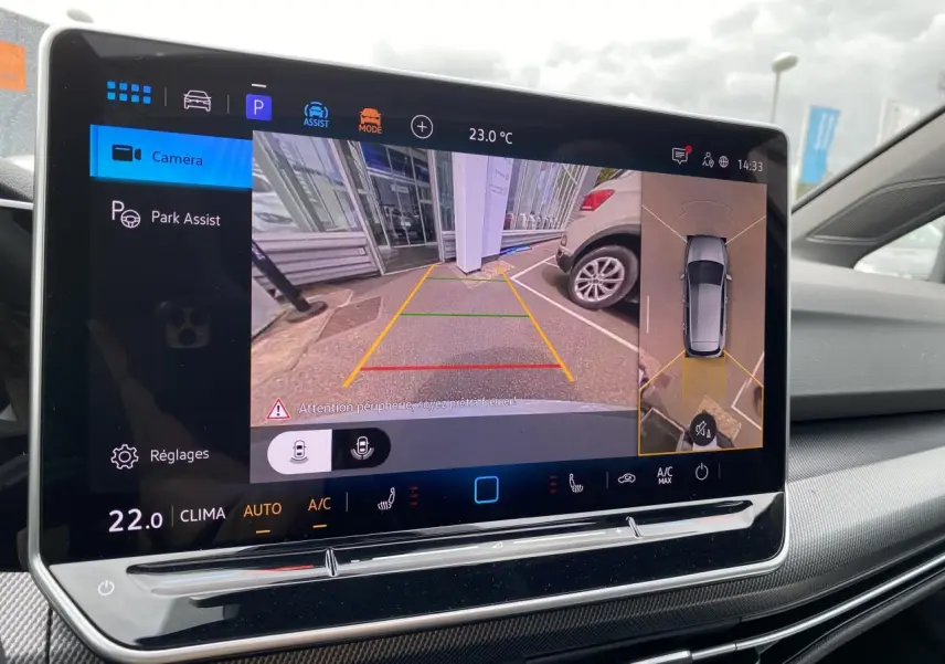 Écran tactile intérieur affichant la caméra 360° et l'assistance au stationnement de la Volkswagen Golf VIII R-Line blanc Oryx.