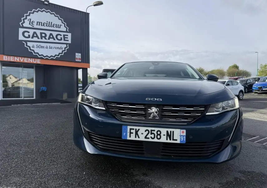 Vue frontale d'une Peugeot 508 bleue métallisée avec calandre chromée et plaque d'immatriculation française.