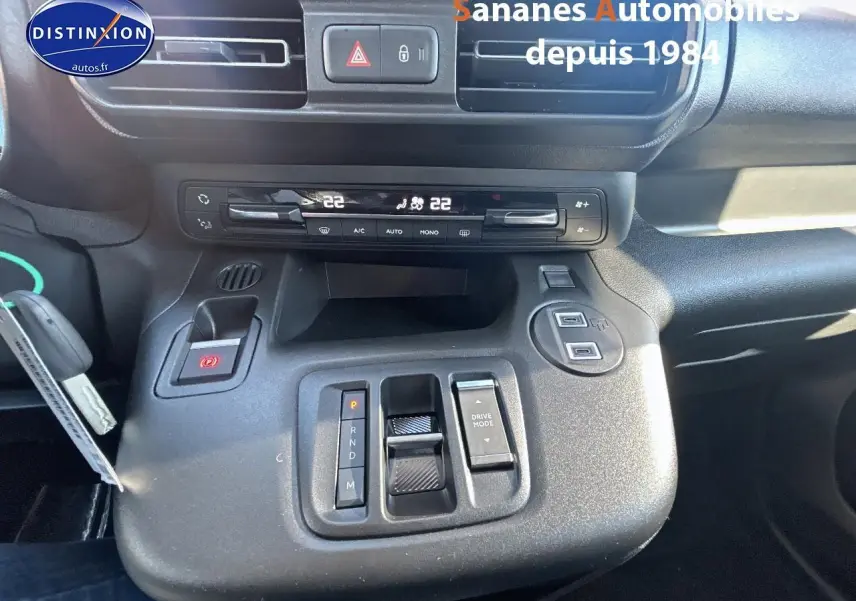 Vue rapprochée de la console centrale noire du Citroën Berlingo 2025 avec commandes de climatisation et boîte automatique.