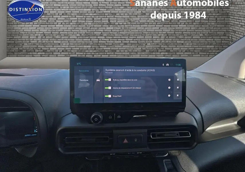 Vue intérieure du tableau de bord du Citroën Berlingo blanc, écran tactile central affichant l'aide à la conduite.