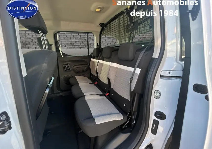 Vue latérale droite sur les sièges arrière gris et noirs du Citroën Berlingo blanc avec porte ouverte.