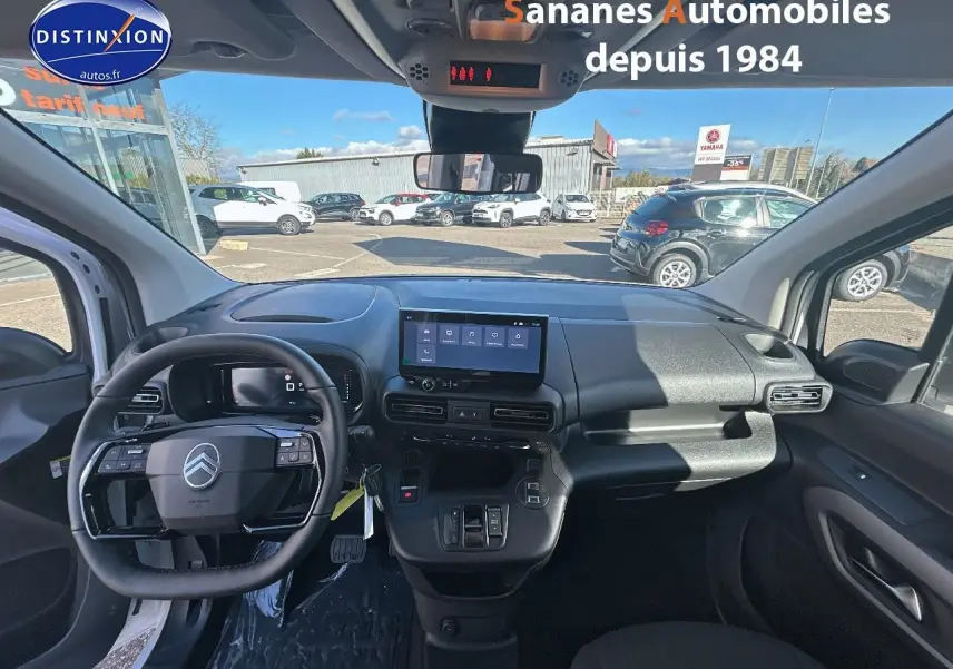 Vue intérieure avant du Citroën Berlingo blanc 2025, tableau de bord moderne avec écran tactile central et volant multifonction.