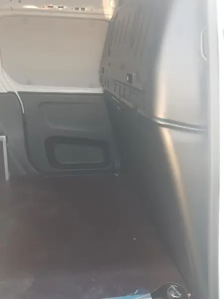 Vue intérieure du compartiment de chargement du Citroën Berlingo blanc, montrant la paroi et le plancher du van.