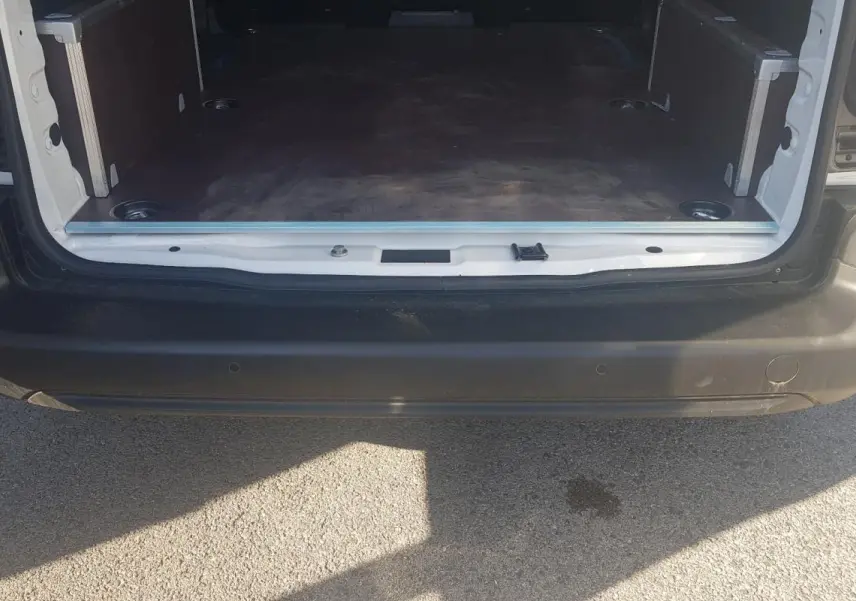 Vue arrière du coffre ouvert d’un Citroën Berlingo blanc 2025, montrant l’espace de chargement vide.