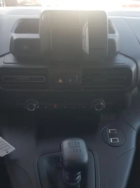 Vue intérieure centrée sur la console et levier de vitesses manuelle du Citroën Berlingo blanc 2025.