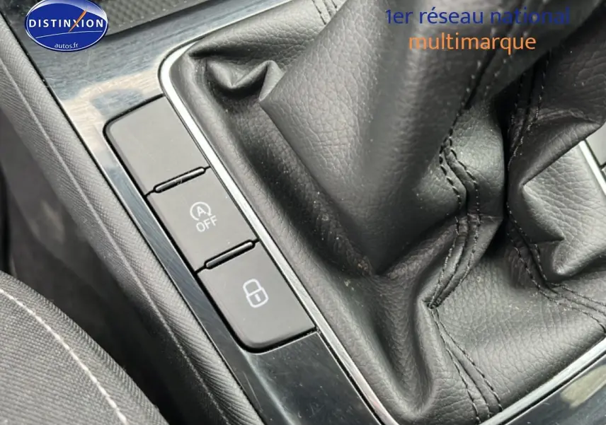 Gros plan sur la console centrale noire de la Skoda Fabia blanche, avec levier de vitesse manuel et boutons de commande.