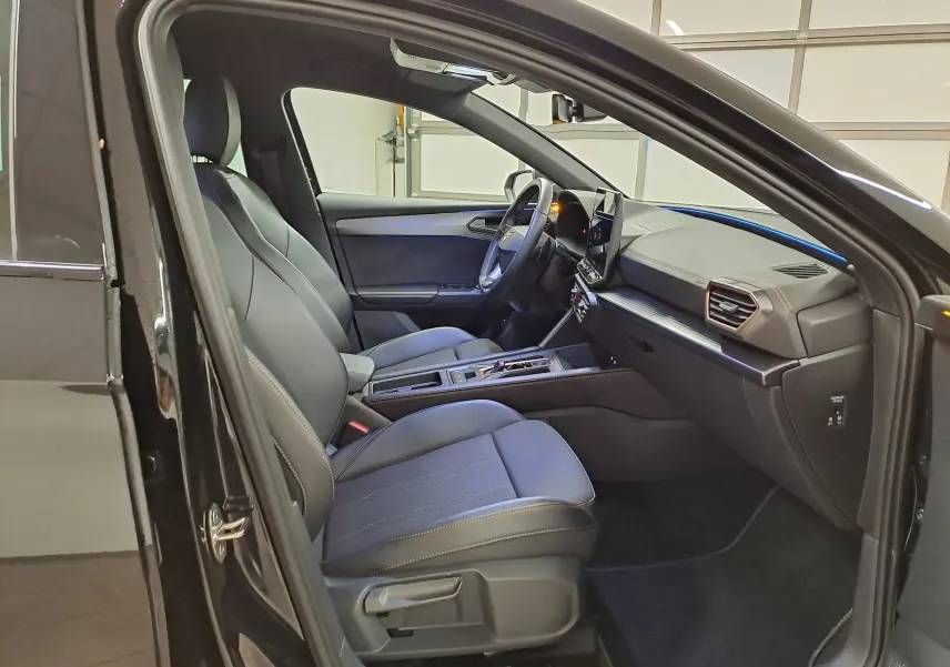 Intérieur avant droit de la CUPRA LEON ST 1.5 eTSI 150 DSG7 noir minuit, sièges en tissu avec surpiqûres contrastées.
