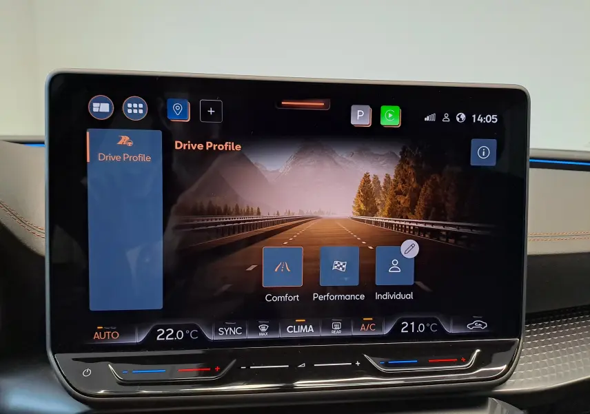Écran tactile central affichant les modes de conduite et la climatisation dans une CUPRA LEON ST 2025 noir minuit.