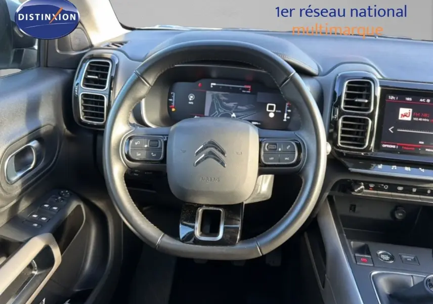 Vue intérieure centrée sur le volant cuir noir et le tableau de bord numérique du Citroën C5 Aircross 2021 gris Artense.