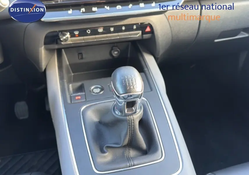 Gros plan sur la commande de la boîte manuelle noire dans l’habitacle sombre d’une Citroën C5 Aircross gris Artense.