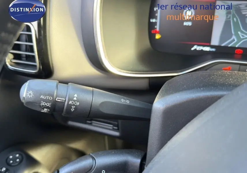 Gros plan sur la manette de clignotant et les commandes d’éclairage du tableau de bord d’un Citroën C5 Aircross gris Artense.