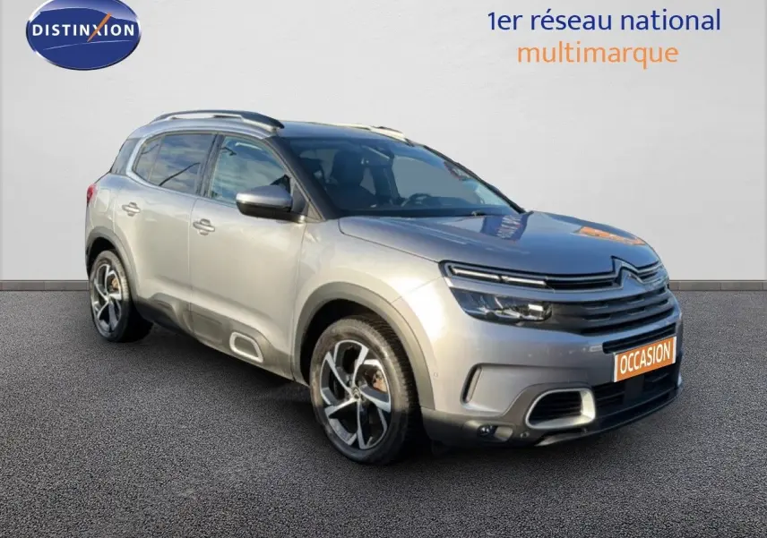 Vue 3/4 avant droit d'un Citroën C5 Aircross gris Artense métal avec jantes bi-ton et signature lumineuse LED.