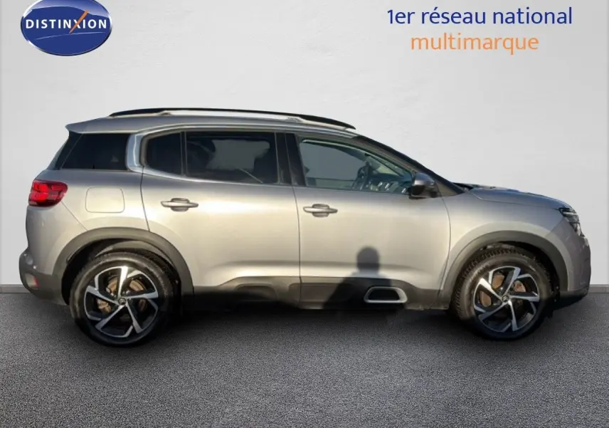 Vue de profil côté gauche d'un Citroën C5 Aircross gris Artense métal avec jantes alliage bicolores.