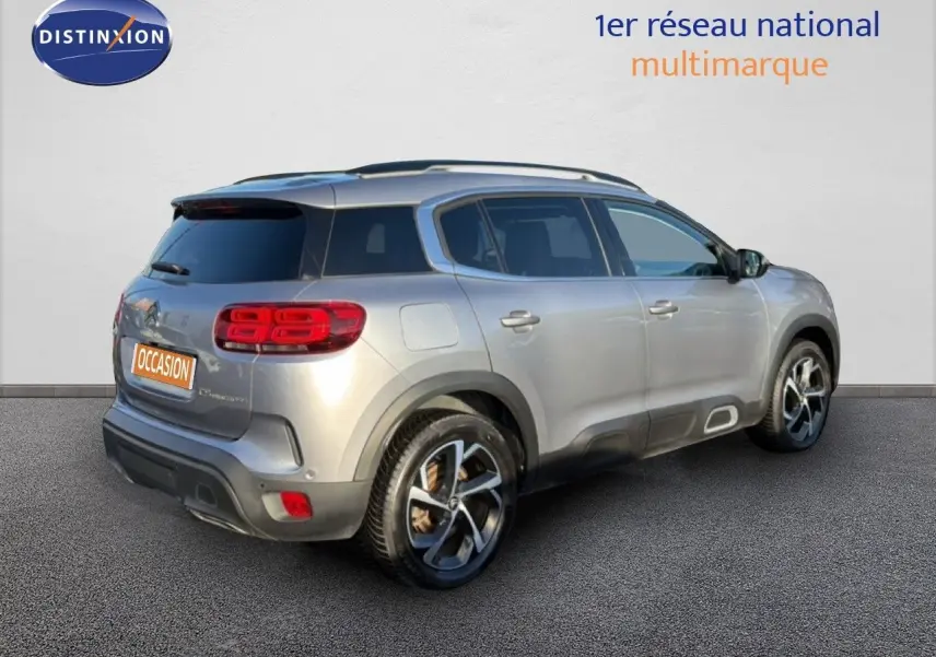 Vue 3/4 arrière droite d'un Citroën C5 Aircross gris Artense métal avec feux arrière LED et jantes bicolores.