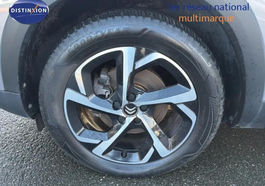 Gros plan sur la roue avant gauche du Citroën C5 Aircross gris Artense métal avec jante alliage bicolore.