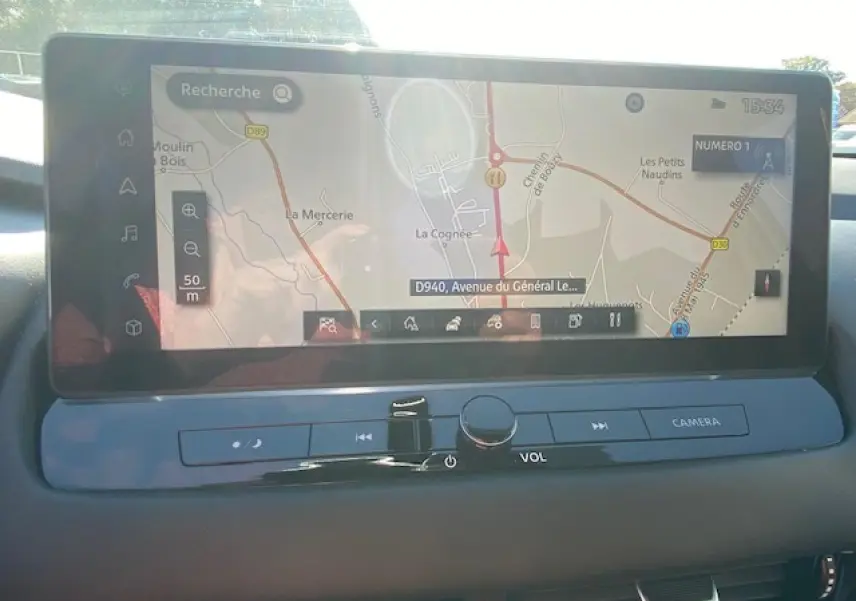 Écran tactile du système de navigation du Nissan Qashqai 2023 noir, vue intérieure centrée sur la console.
