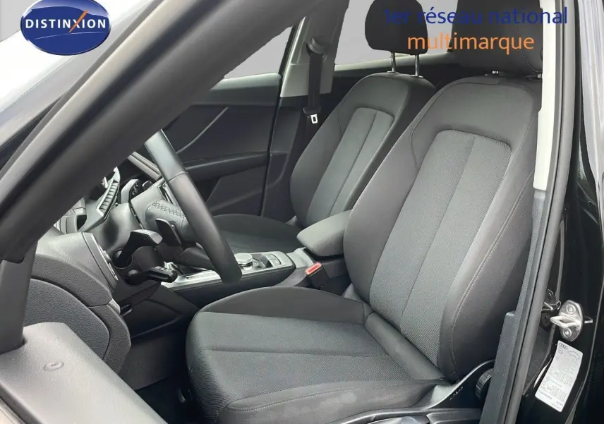 Intérieur noir de l'Audi Q2 35 TFSI 2023 vu côté gauche, avec sièges tissu et volant multifonction.