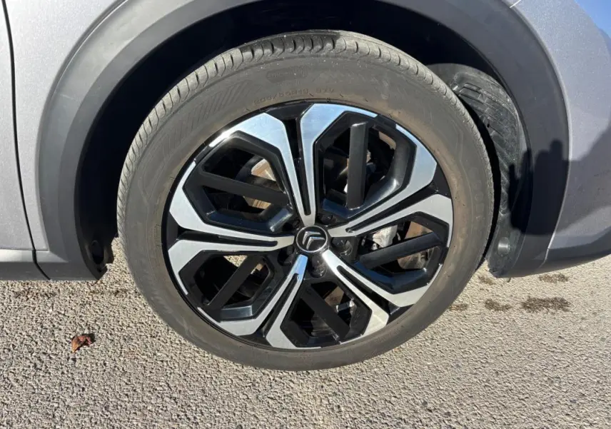 Gros plan sur la jante alliage 19 pouces noire et argentée du côté avant droit du Citroën C5 X gris foncé 2024.