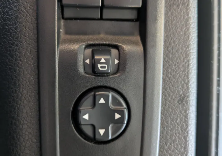 Gros plan sur les commandes de réglage des rétroviseurs côté conducteur de l’Opel Vivaro Fourgon blanc Icy 2024.