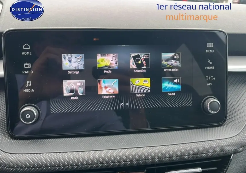 Écran tactile central du tableau de bord de la Skoda Fabia bleu, affichant les options multimédia et assistance conducteur.