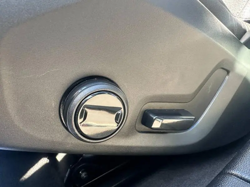 Gros plan sur les commandes de réglage de siège noir dans l'habitacle d'une Volvo S60 gris Platinium Métallisé 2024.