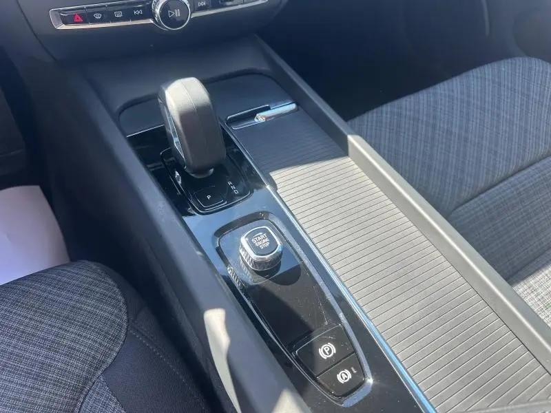 Vue rapprochée de la console centrale du Volvo S60 2024, avec levier de boîte auto et bouton start/stop.