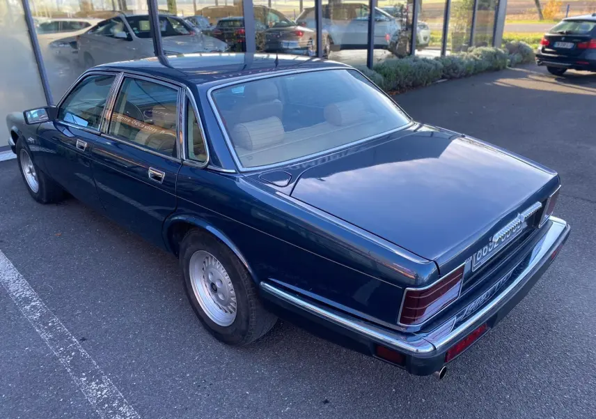 Jaguar XJ6 3.6 Sovereign bleu vue 3/4 arrière droit, carrosserie brillante et jantes classiques en alliage.