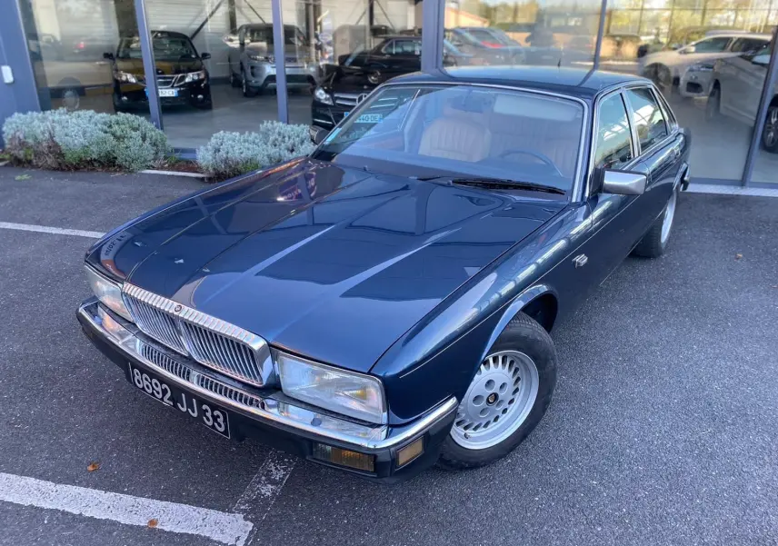 Jaguar XJ6 3.6 Sovereign bleu vue 3/4 avant droit, avec calandre chromée et jantes alliage classiques.