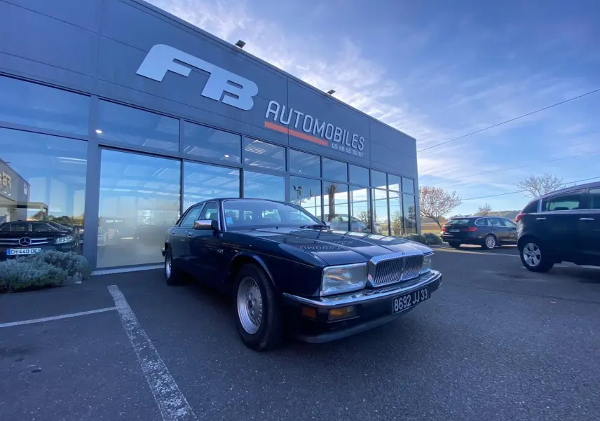 Jaguar XJ6 3.6 Sovereign bleu vue 3/4 avant droit devant concession FB Automobiles par temps clair.