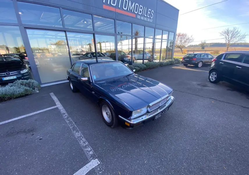 Jaguar XJ6 3.6 Sovereign bleu 1987 vue 3/4 avant droit, avec calandre chromée et jantes d'origine.