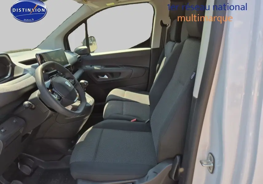 Intérieur du Peugeot Partner 2025 vu côté droit, montrant les sièges gris et le tableau de bord noir.