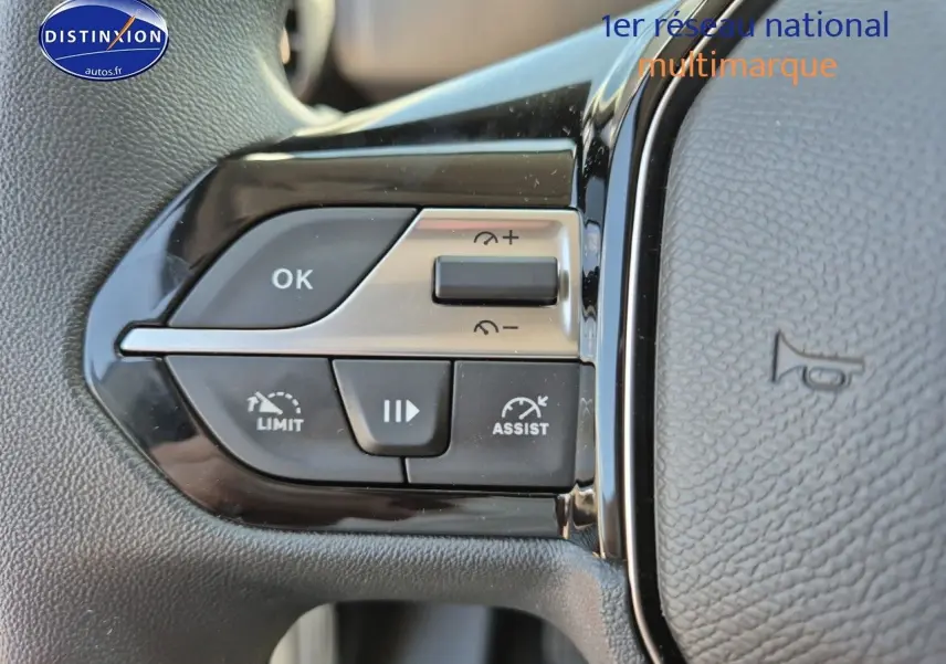 Gros plan sur les commandes de régulateur de vitesse au volant noir du Peugeot Partner 2025.