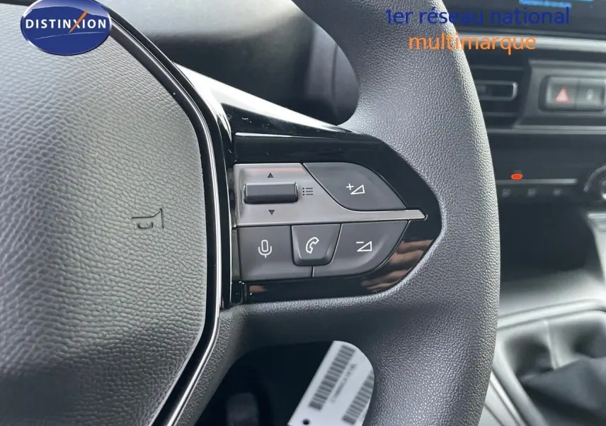 Gros plan sur le volant côté gauche du Peugeot Partner 2025, avec commandes audio et téléphone intégrées.