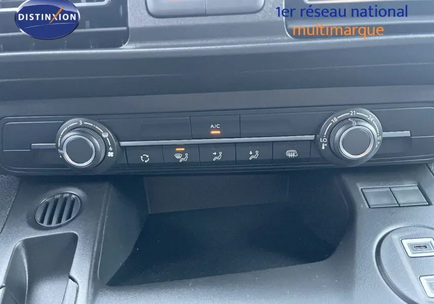 Vue rapprochée de la console centrale noire du Peugeot Partner 2025, avec commandes de climatisation et ventilation.