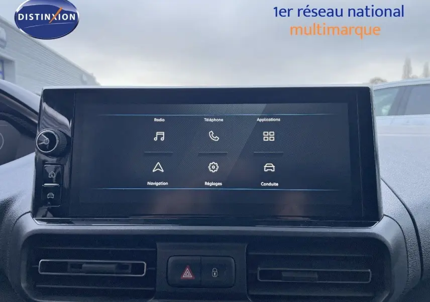 Écran tactile central du tableau de bord du Peugeot Partner 2025, vue frontale intérieure avec commandes visibles.