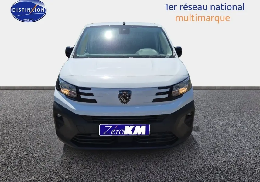 Vue frontale d'un Peugeot Partner blanc 2025 avec calandre noire et logo lion central bien visible.