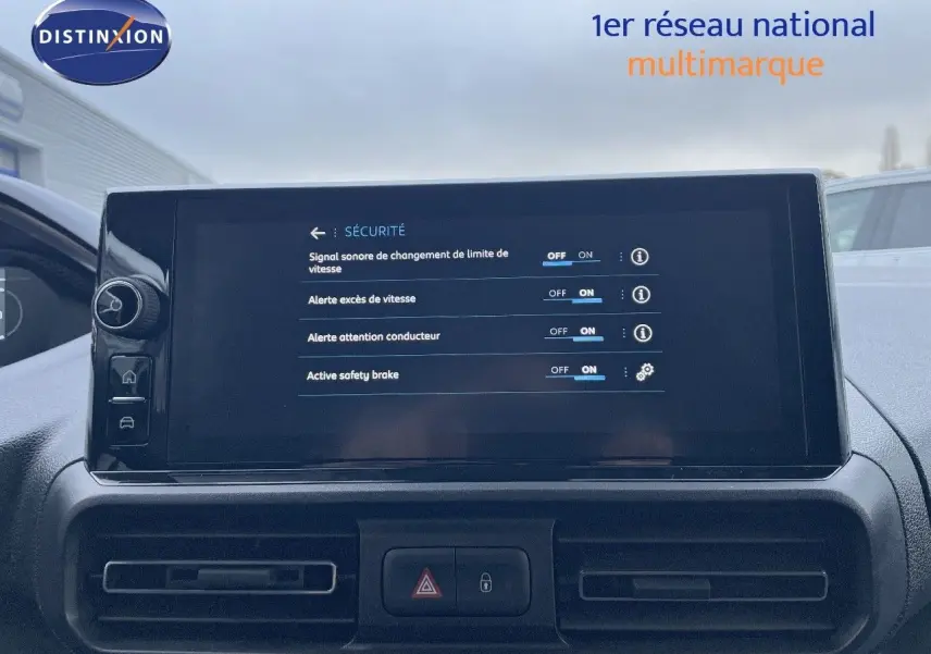 Vue intérieure du tableau de bord du Peugeot Partner 2025, écran tactile affichant les options de sécurité, ambiance sobre et moderne.