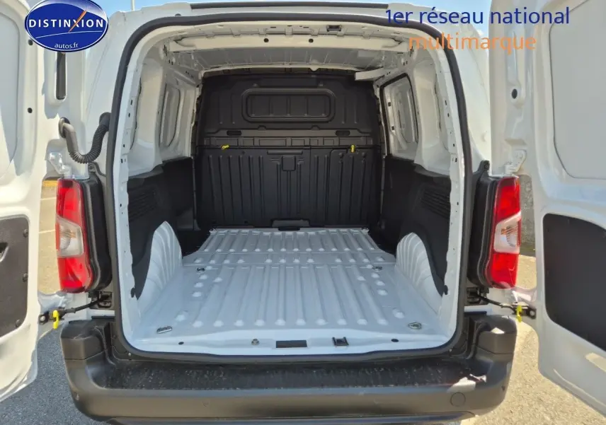 Vue arrière du Peugeot Partner 2025 blanc avec portes ouvertes montrant l'espace de chargement vide et la cloison noire.