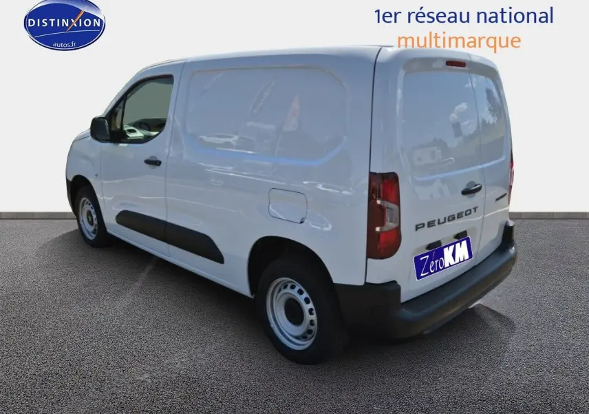 Vue 3/4 arrière droite d'un Peugeot Partner blanc 2025 avec logo et plaque Zero KM visible sur fond neutre.