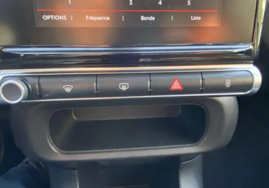 Boutons de commande de la console centrale de la Citroën C3 2017 noire avec toit rouge, incluant les feux de détresse et verrouillage.