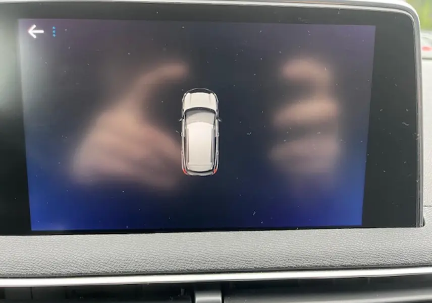 Écran tactile intérieur affichant la vue aérienne du Peugeot 3008 gris Amazonite, avec tableau de bord en cuir gris.