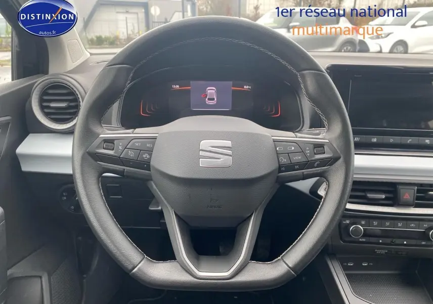 Vue centrée sur le volant cuir méplat de la SEAT Ibiza noir minuit, avec tableau de bord digital et écran tactile.