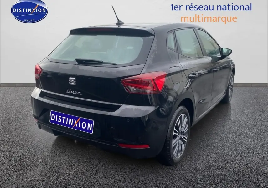 Vue 3/4 arrière droite d'une SEAT Ibiza noir minuit avec jantes alliage et feux arrière LED triangulaires visibles.