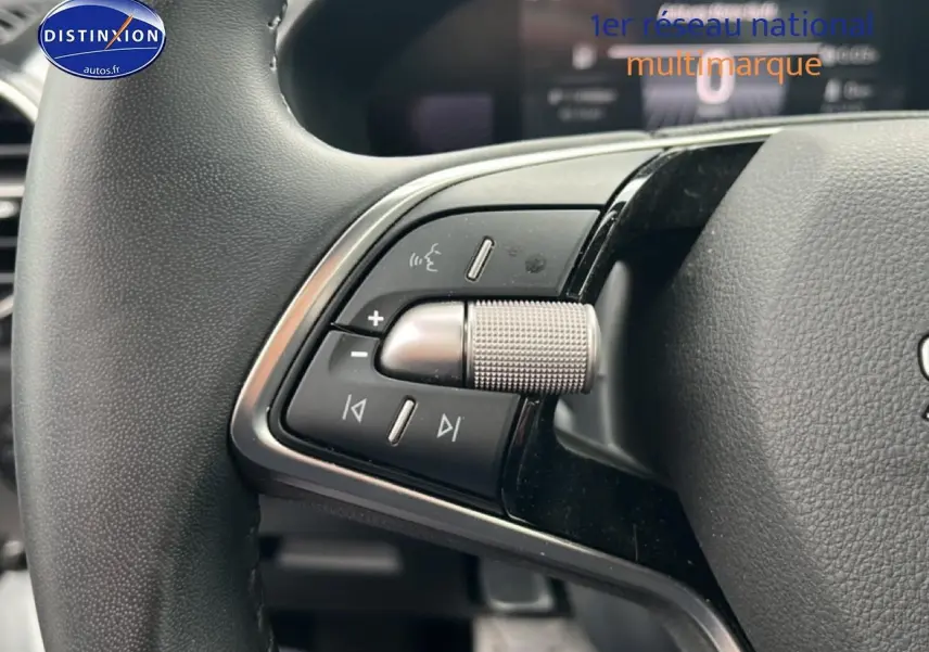 Gros plan sur les commandes audio au volant cuir noir d'une Skoda Fabia blanche, version 2025, essence.