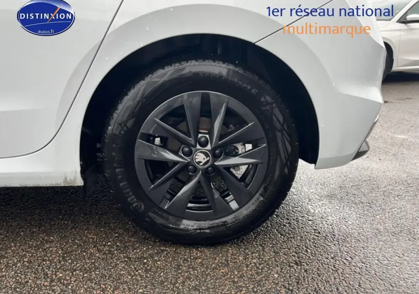 Gros plan sur la roue arrière droite noire avec jante alu d'une Skoda Fabia blanche essence 2025.