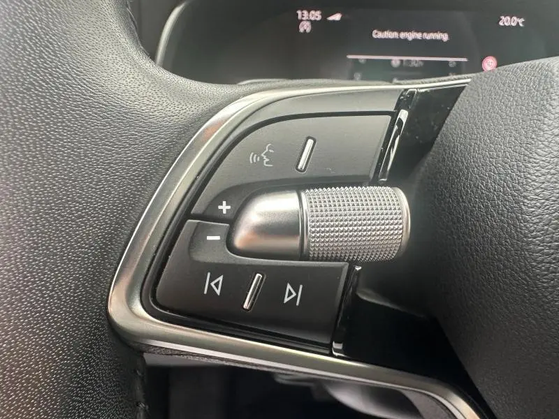 Gros plan sur les commandes multifonctions en noir et chrome du volant cuir d'une Skoda Scala blanc cristal 2025.