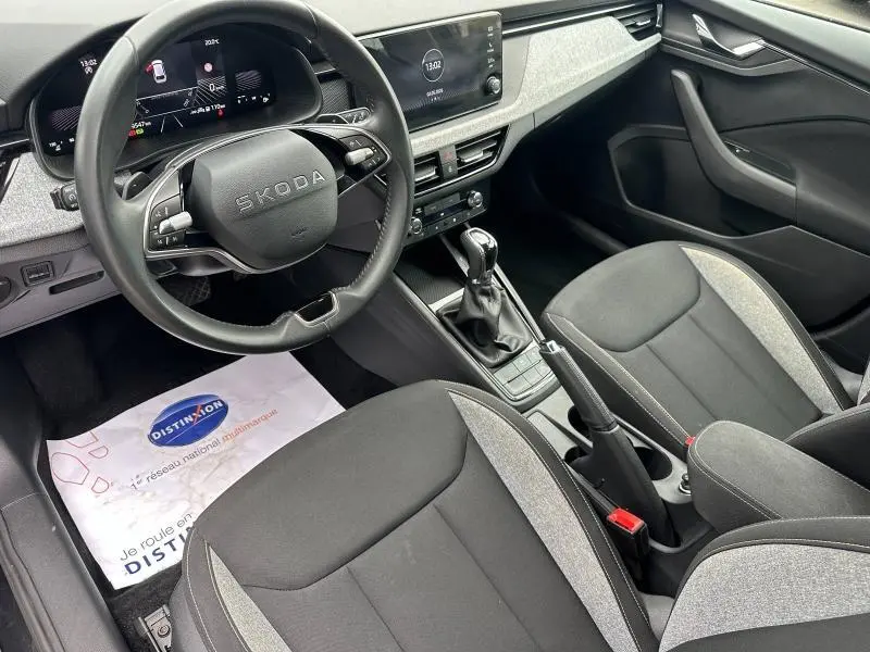 Vue intérieure de la Skoda Scala 2025 montrant le volant cuir multifonction et la console centrale avec boîte auto.