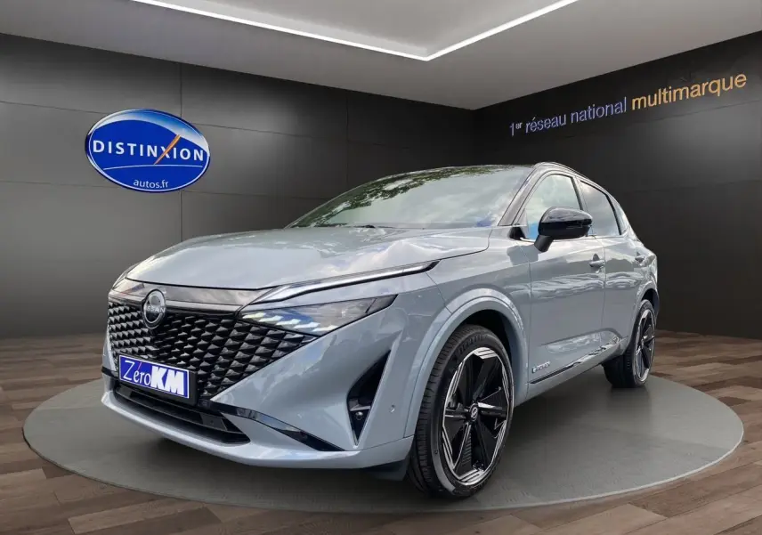 Nissan Qashqai 1.5 e-POWER 2025 gris ceramic et noir, vue 3/4 avant avec calandre noire distinctive et jantes stylées.