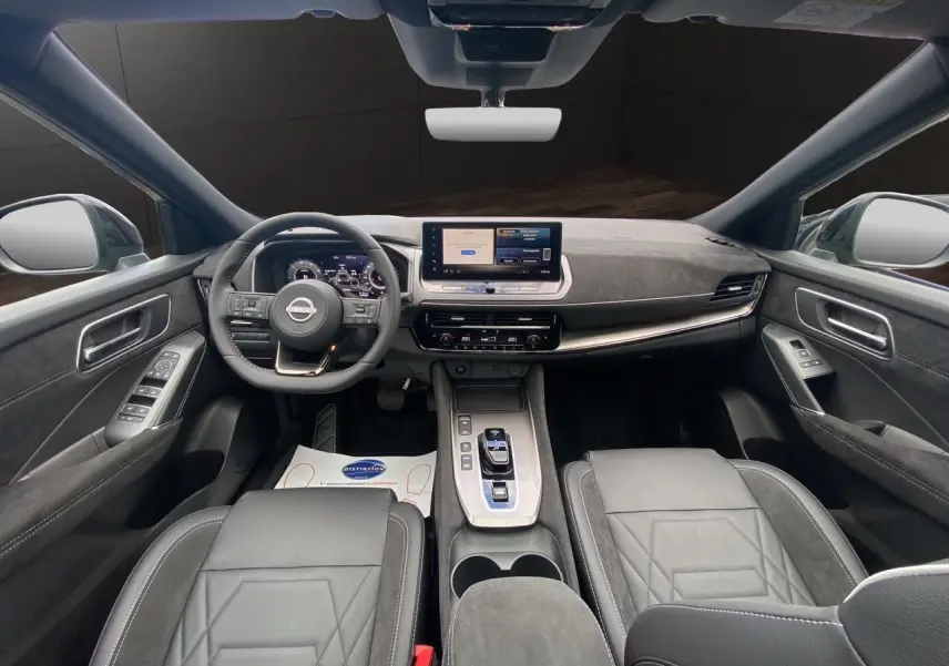 Vue intérieure avant du Nissan Qashqai 1.5 e-POWER 2025 avec tableau de bord numérique et sellerie cuir noir.