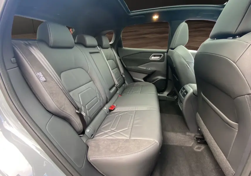 Vue intérieure côté droit des sièges arrière en cuir noir du Nissan Qashqai 1.5 e-POWER 2025 avec toit panoramique.